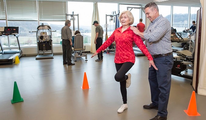 Researcher with participant doing exercise in lab