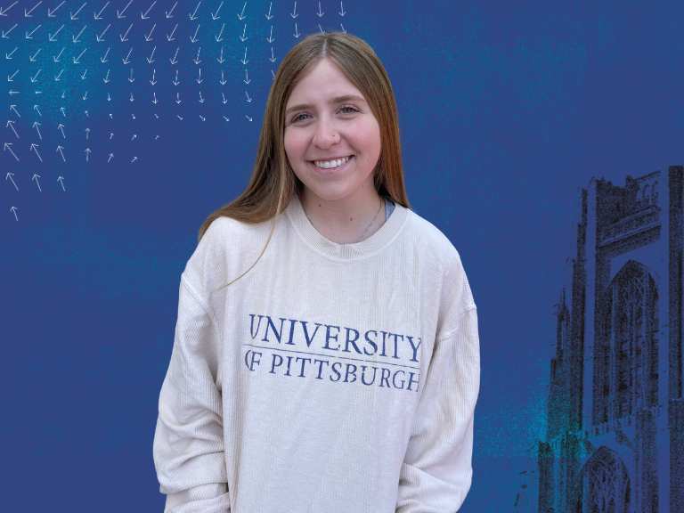 A woman with brown hair in a white University of Pittsburgh sweatshirt against a blue background. 