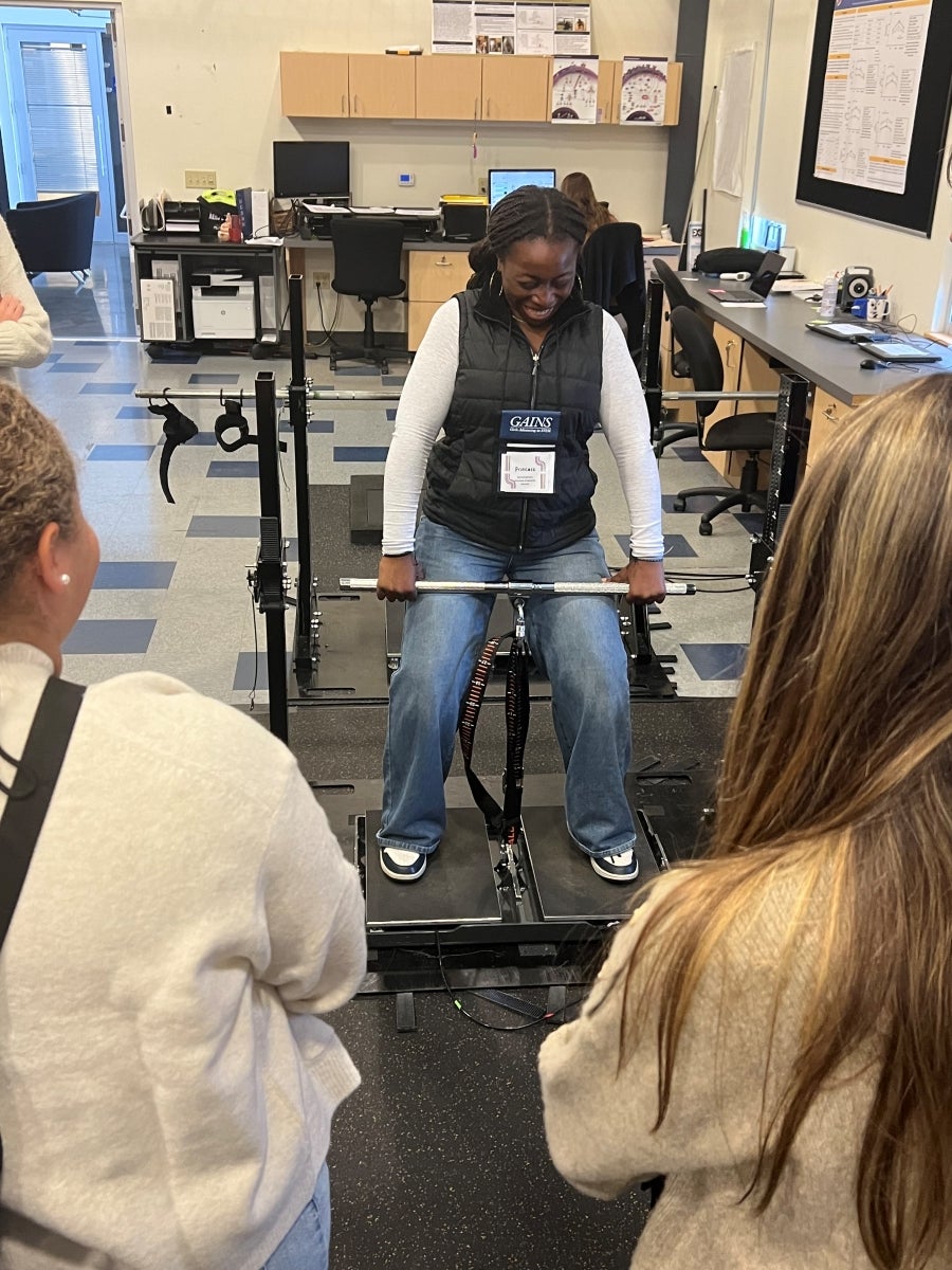 A young woman pulls up on a straight bar to test strength