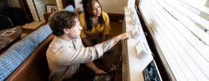 Male and female student analyzing data from a smart device.