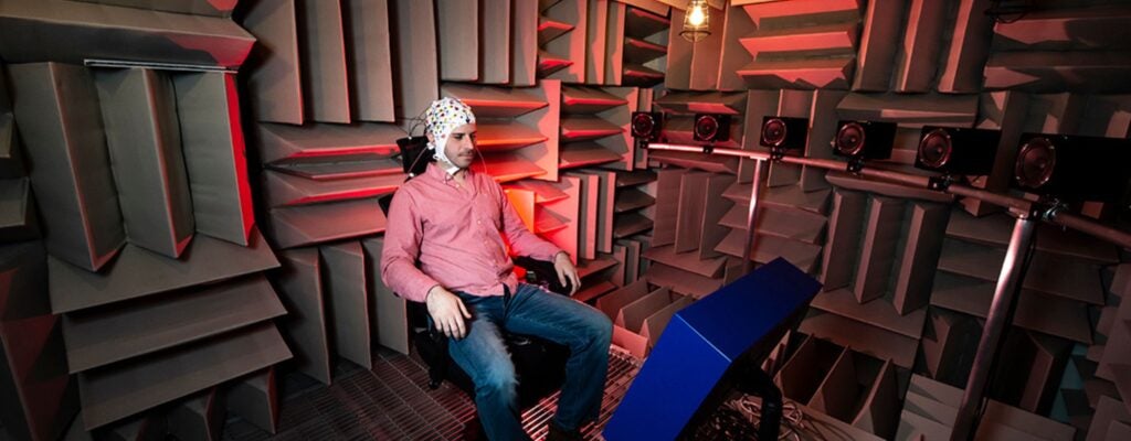 Research subject sitting in room with textured sound panels.