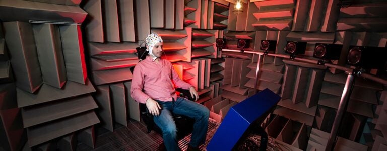 Research subject sitting in room with textured sound panels.