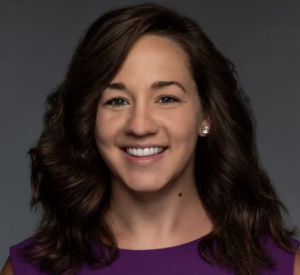 Woman with dark brown hair wearing dark purple.