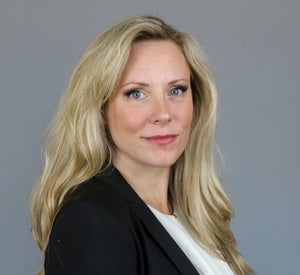 Woman with long blonde hair wearing black blazer.