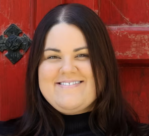 Woman with dark auburn hair wearing a black turtleneck.