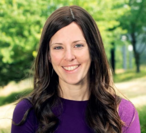 Woman with dark brown hair wearing a dark purple shirt.