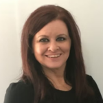 Woman with dark red hair wearing a black blouse.