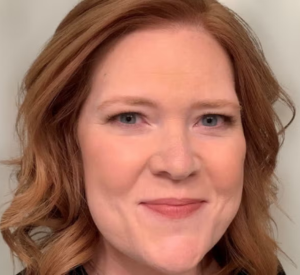 Woman with red hair wearing a black shirt.