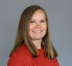 Woman with brown hair wearing a red top.