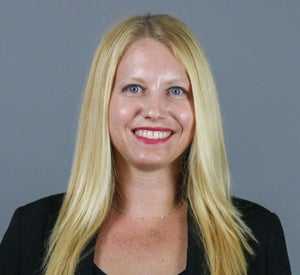 Woman with long blonde hair wearing a black blazer.