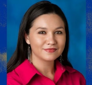 Woman with dark hair wearing a red collared shirt.