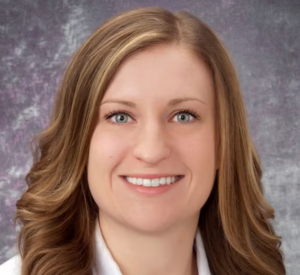 Woman with light brown hair wearing a white blazer.