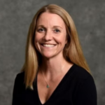 Woman with dark blonde hair wearing a black shirt.