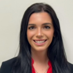 Woman with black hair wearing a black blazer over a red blouse.