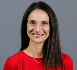 Woman with long dark brown hair wearing a red shirt.