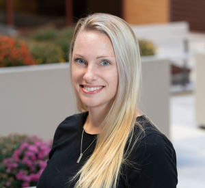 Woman with long blonde hair wearing a black blouse.