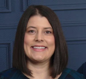 Woman with short black hair wearing a dark blue shirt.