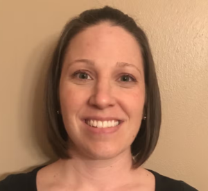 A woman with short brown hair wearing a black shirt.