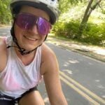 A woman riding a bicycle takes a selfie