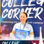 Ashley Koto standing in front of a backdrop with the words College Corner while holding a small sign saying Pittsburgh Panther in Paris