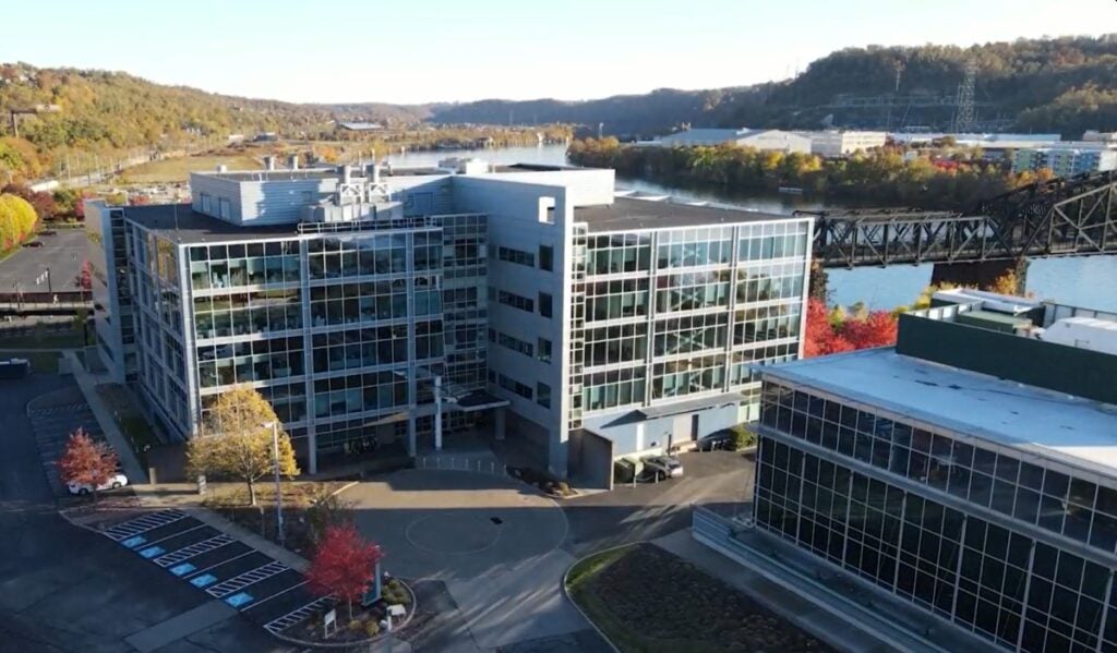 An aerial shot of a five story building along a river