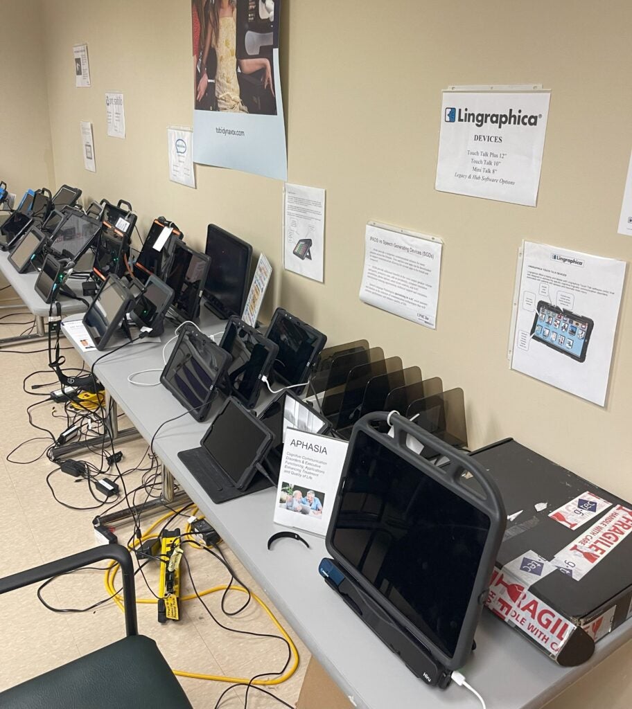 A table displays a variety of devices used at the Center for Assistive Technology.