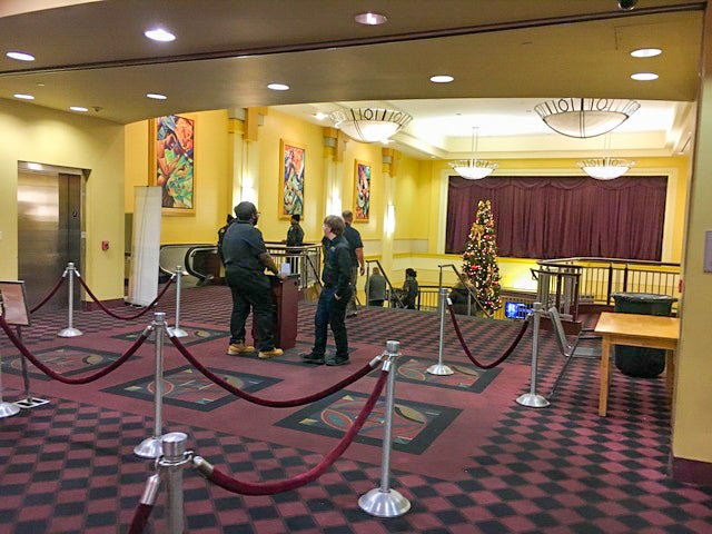 A room at the top of a stairway with people waiting to collect tickets for a movie