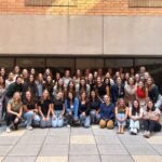 Group of students gathered together sitting and standing in the student atrium.