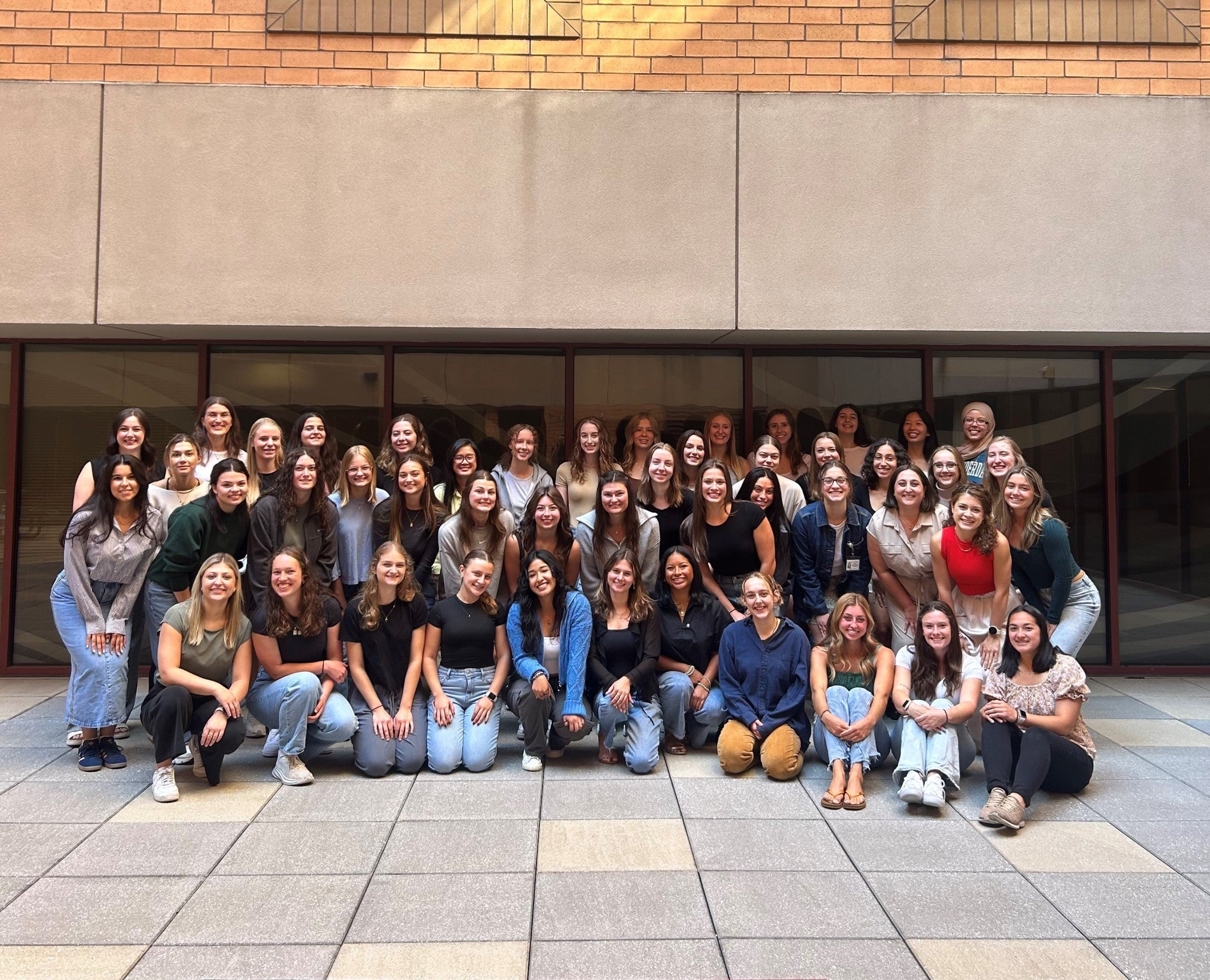 Group of students gathered together sitting and standing in the student atrium.