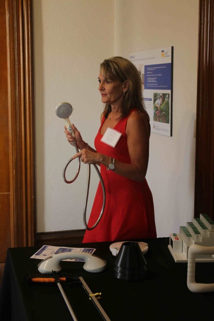 Woman holding assistive technology device.