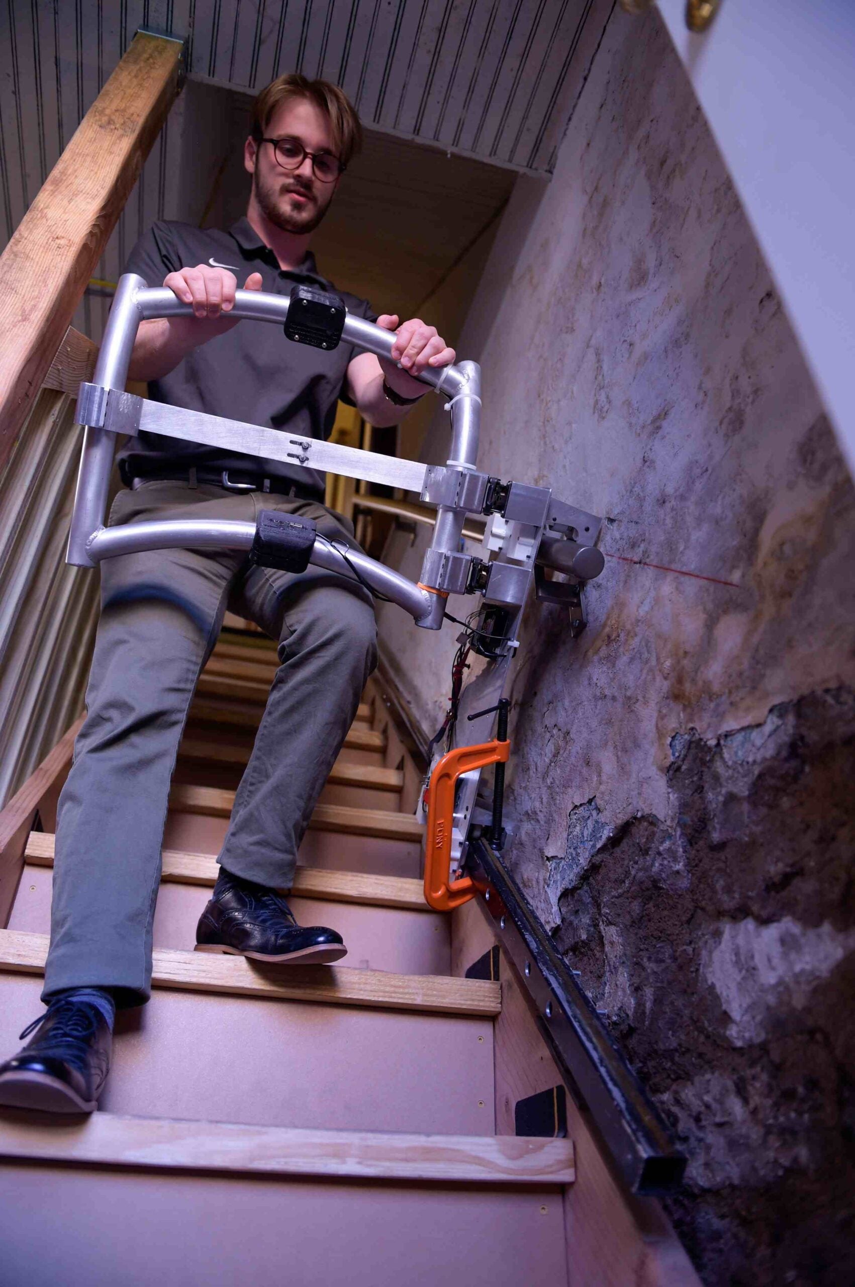 Man using mechanical stairway rail device.