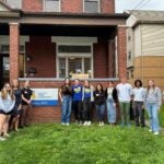 Students from Pitt Occupational Therapy, Dietetics and Nutrition, and Pharmacy with Healthy Home Lab Director Pamela Toto outside the Healthy Home Lab in Oakland.