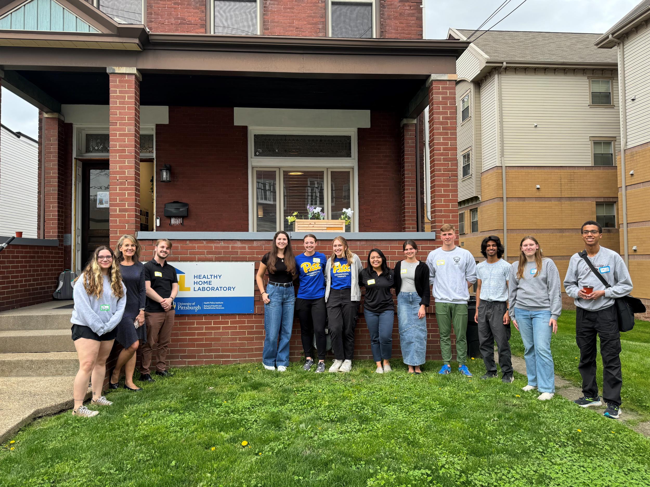 Students from Pitt Occupational Therapy, Dietetics and Nutrition, and Pharmacy with Healthy Home Lab Director Pamela Toto outside the Healthy Home Lab in Oakland.