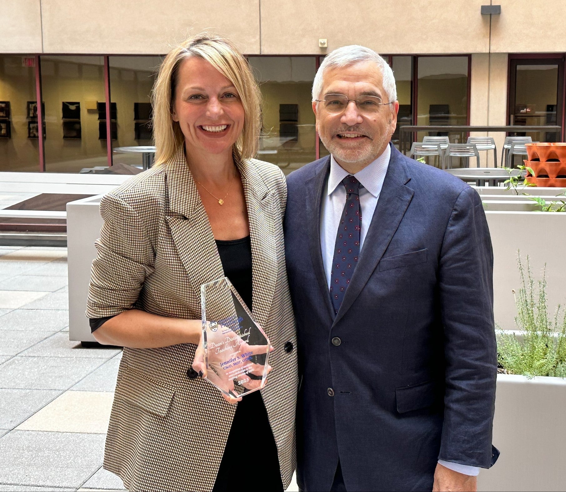 Jennifer White holding award with Dean Anthony Delitto