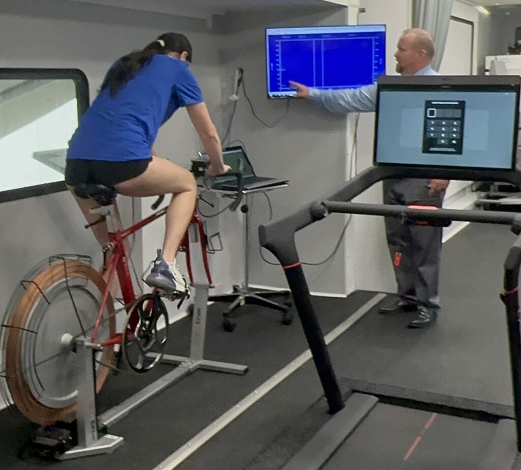 Female athlete riding an indoor bicycle to test performance in a mobile lab environment