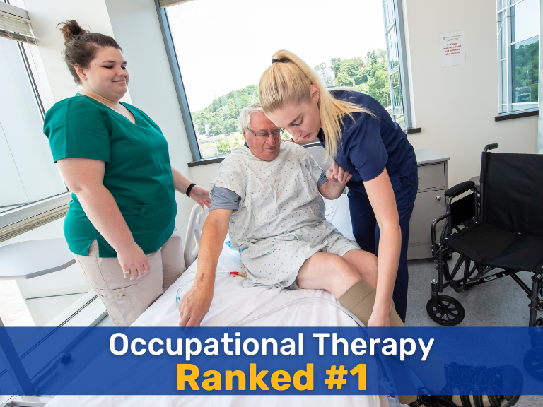 A brunette woman wearing a green scrubs outfit and a blonde woman with a navy blue scrubs outfit helping an elderly man into a bed. Text overlayed onto the image reads "Occupational Therapy Ranked #1"