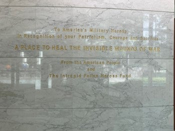 An engraving on a marble wall reads "A place to heal the invisible wounds of war"