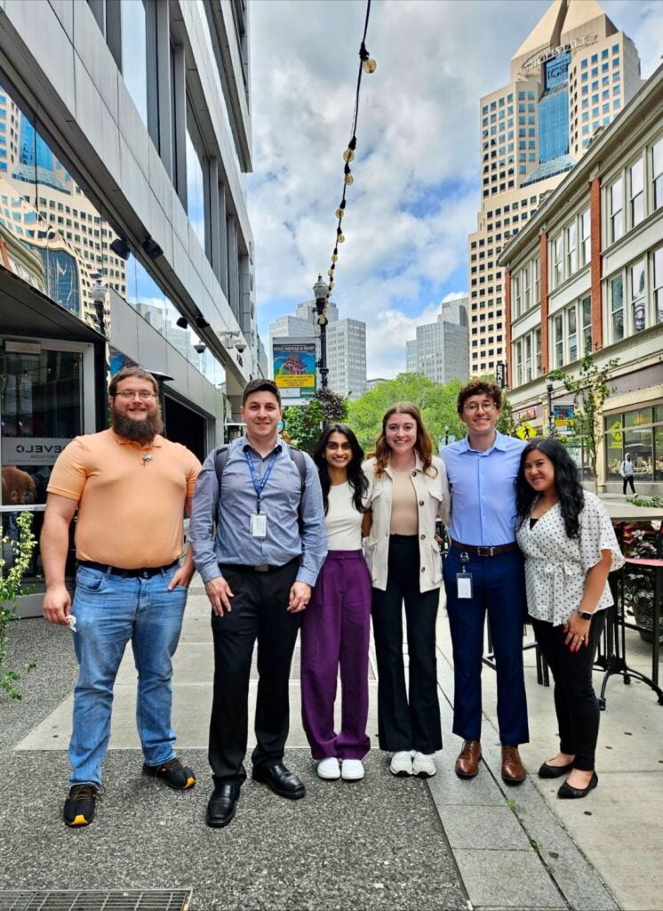 A group of men and women standing together outside in Downtown Pittsburgh.