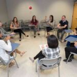 Group of students sitting in a circle in a classroom.