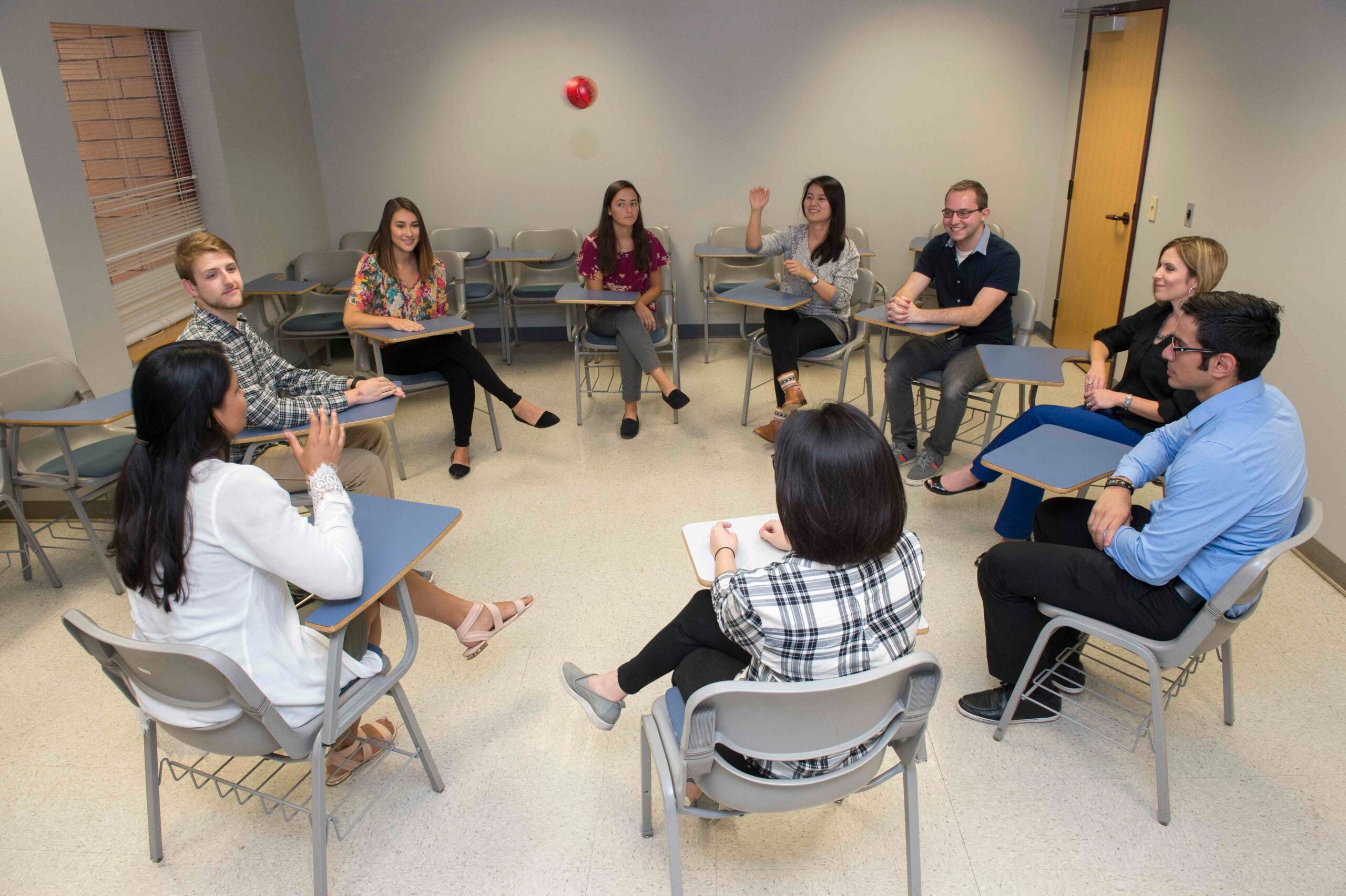 Group of students sitting in a circle in a classroom.