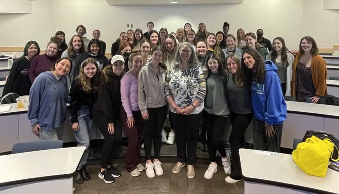 A group of people standing together in a classroom.