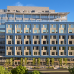 Rendering of a building with numerous glass windows and a blue exterior.