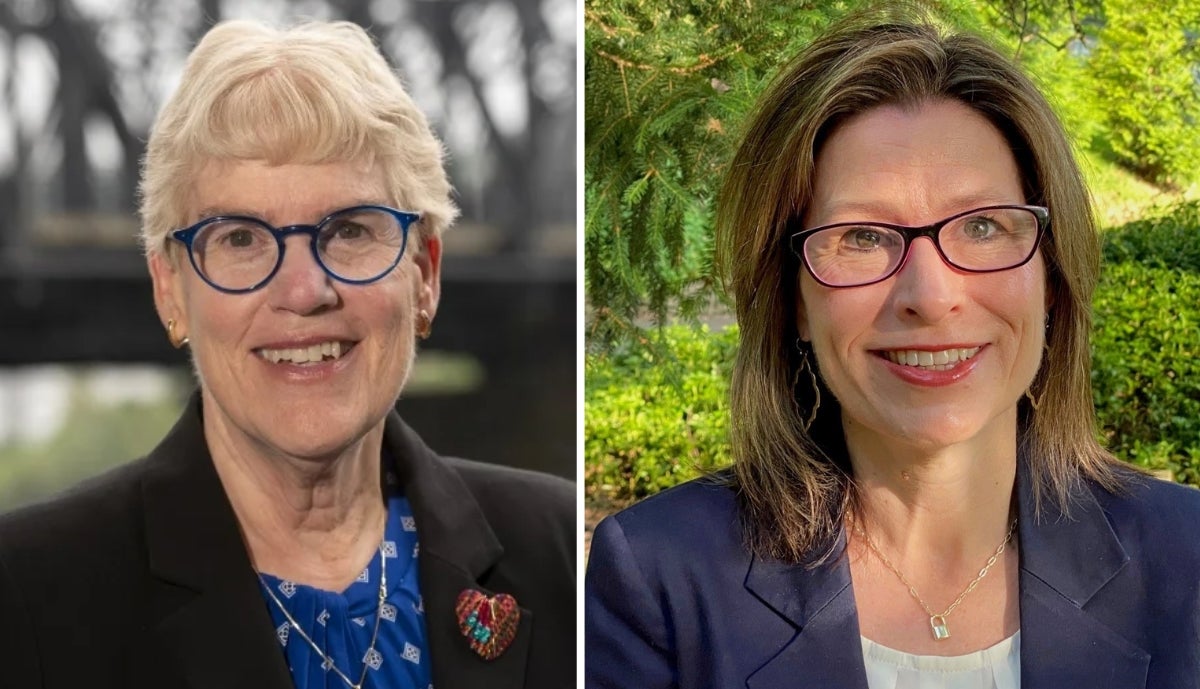 Left: A woman with blonde short hair wearing a black blazer over a dark blue blouse and dark blue glasses. Right: A woman with short brown hair wearing a navy blue blazer over a white blouse with black glasses.