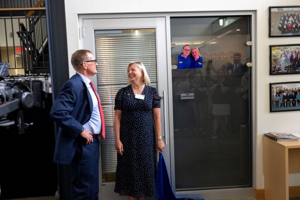 Barry and Jean Rhoads in front of the NMRL conference room named in their honor